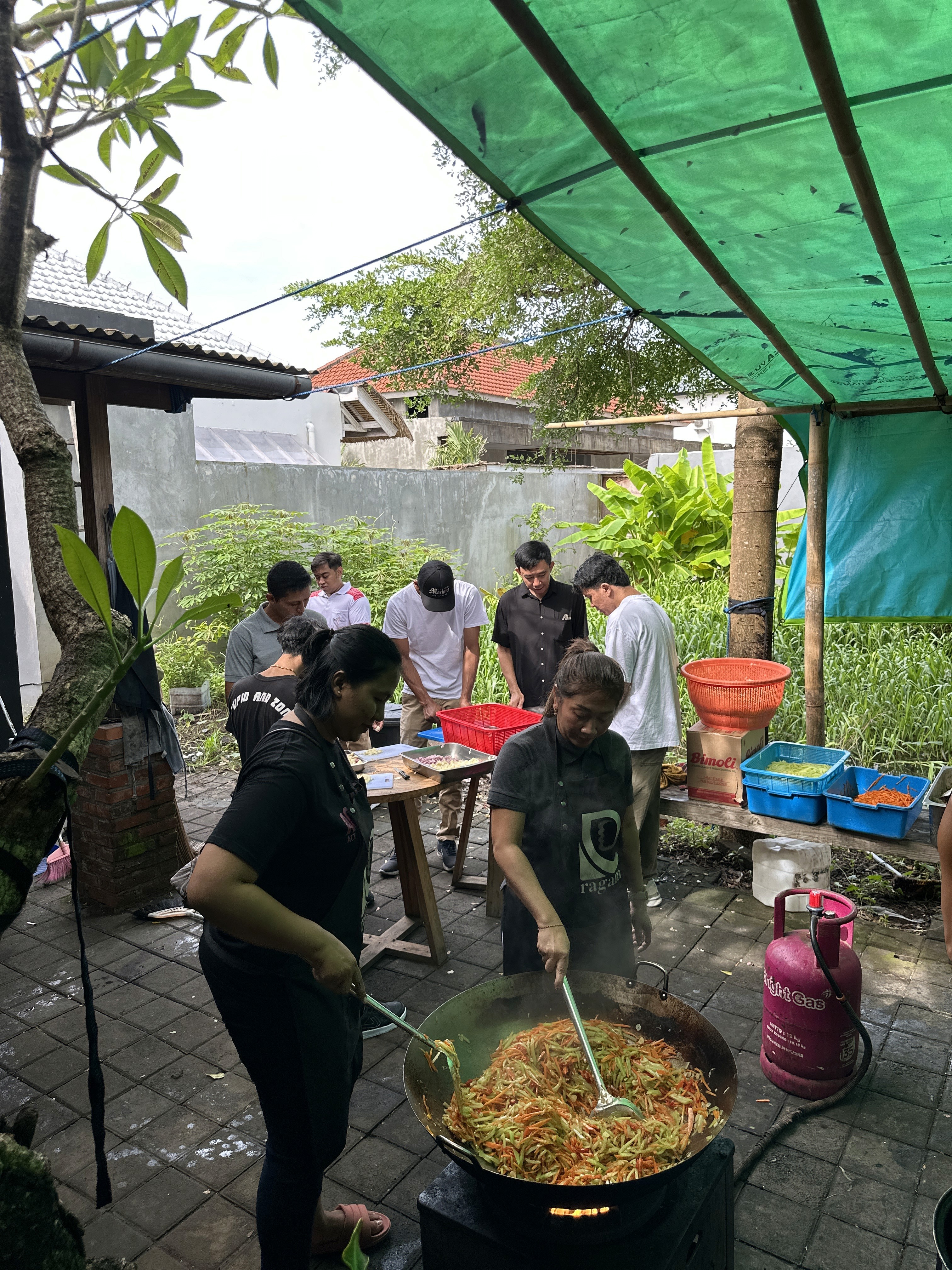 Team of volunteers cooking together at the outdoor community kitchen