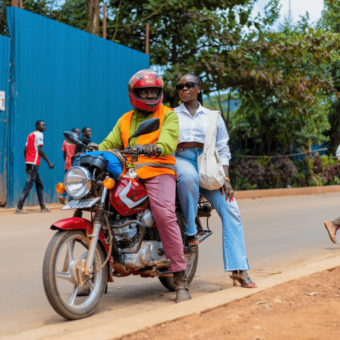 Mary Consolata Namagambe riding side saddle on a motorbike in Uganda, Africa