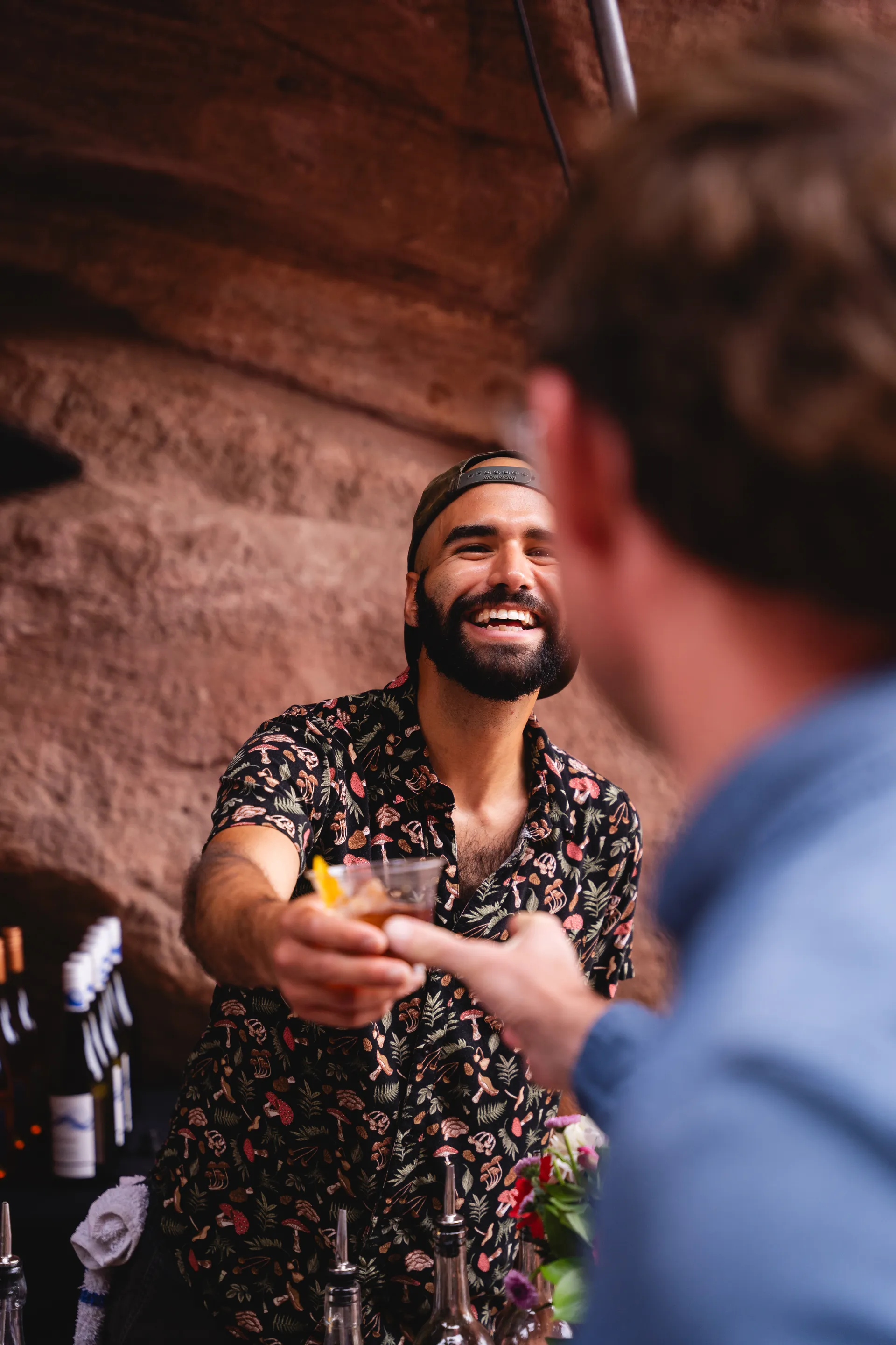Alex handing a guest a cocktail