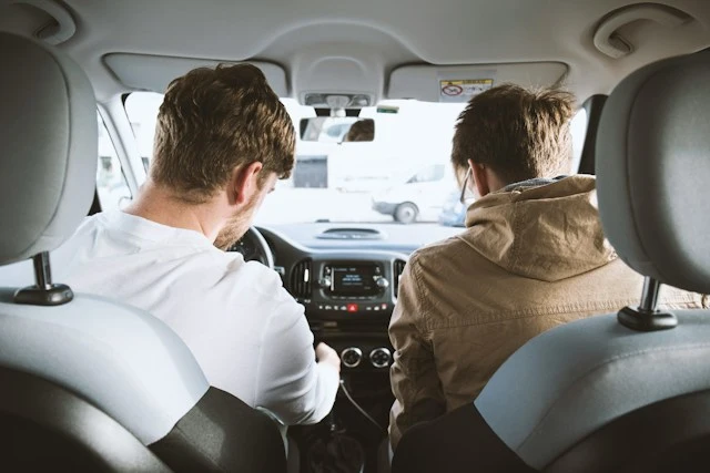 Joven conductor al volante acompañado de otro joven en el asiento del copiloto, ilustrando el seguro de coche para conductor novel de Allianz en Murcia.