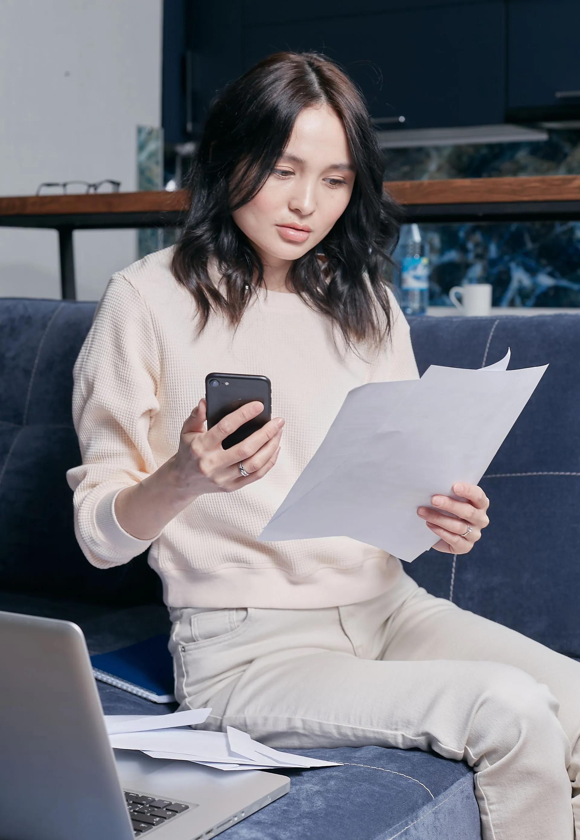 Person looking at a tablet while sitting and writing in an office.