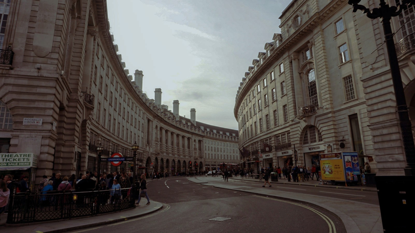 Curved street view of Regent Street in London, lined with historic white stone buildings, photographed by Janice Chen.