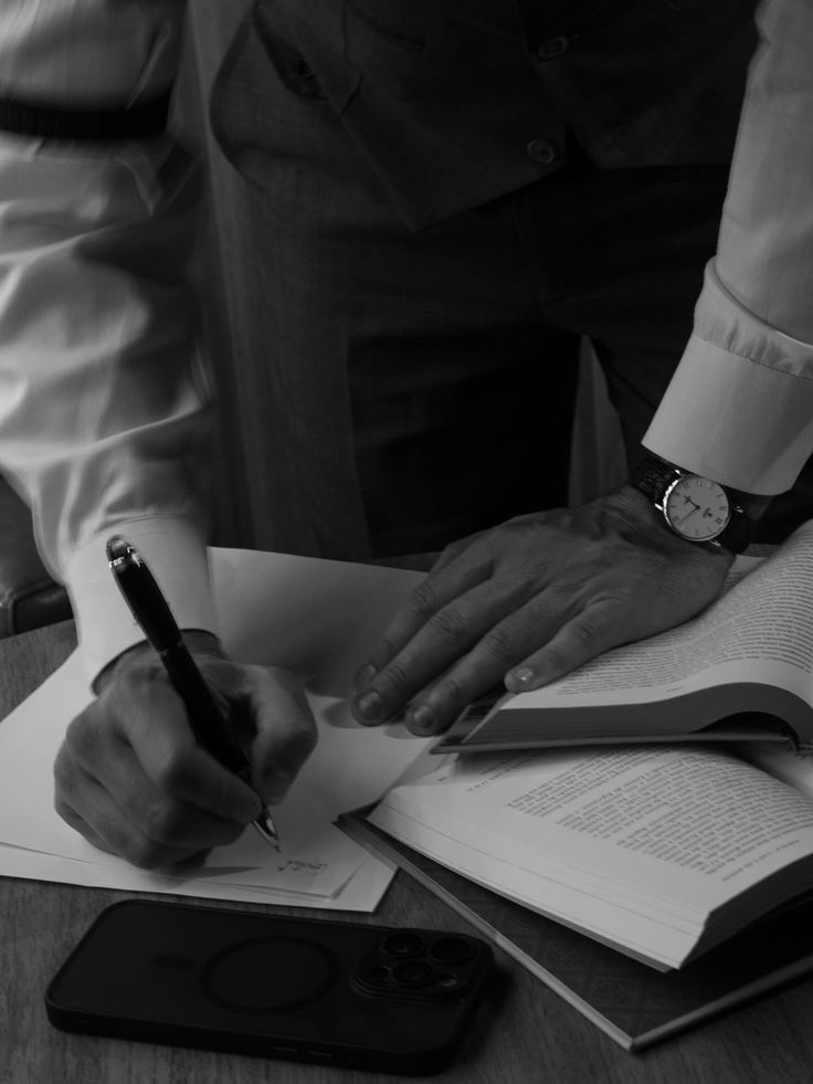 Two businessmen in suits walking down an escalator in a subway station with coffee cups.