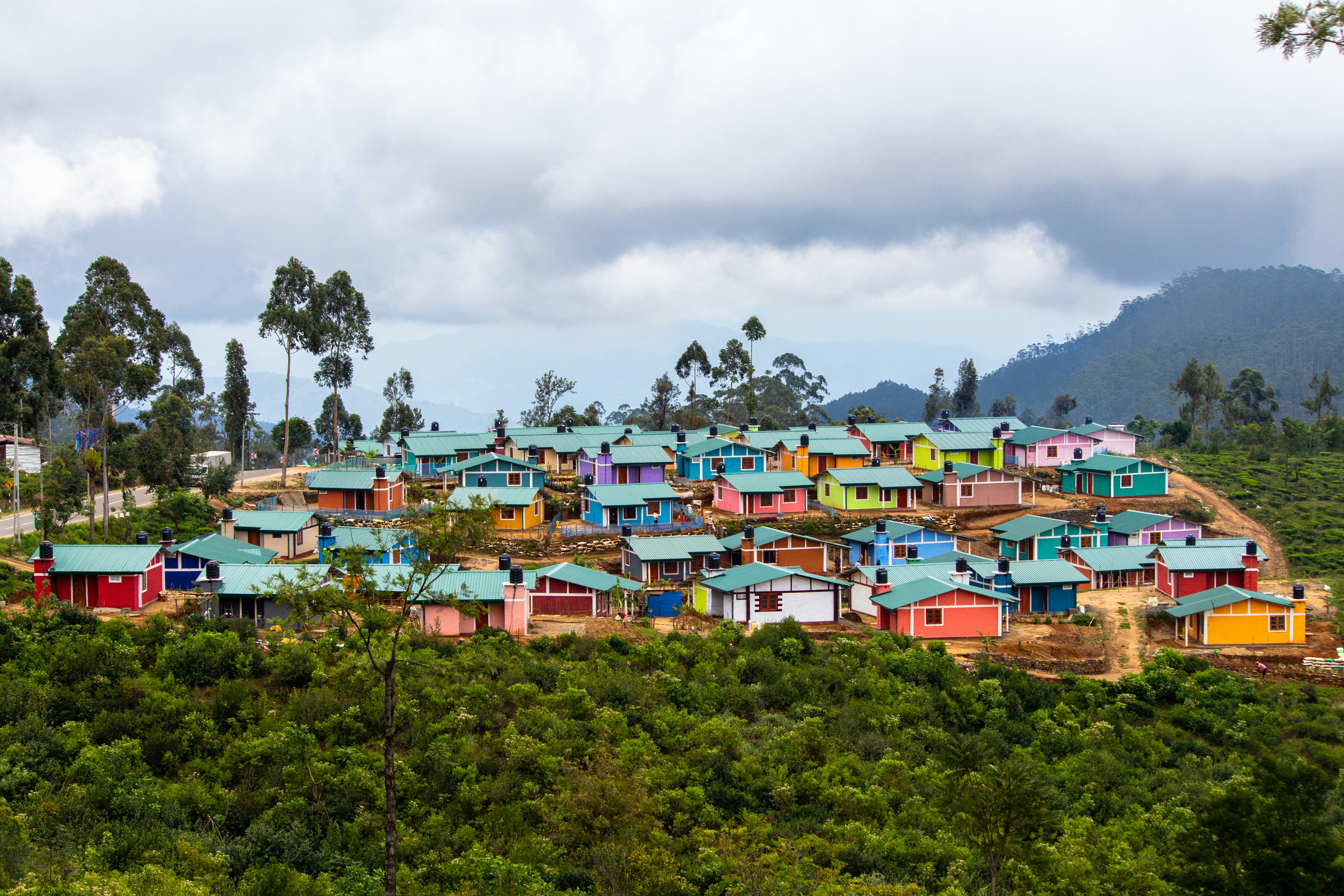 houses on green grass field under white clouds during daytime
