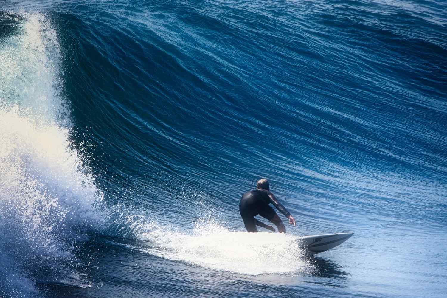 Close-up of a surfer riding inside a perfect barreling wave — surfboard rental in Southeast Asia