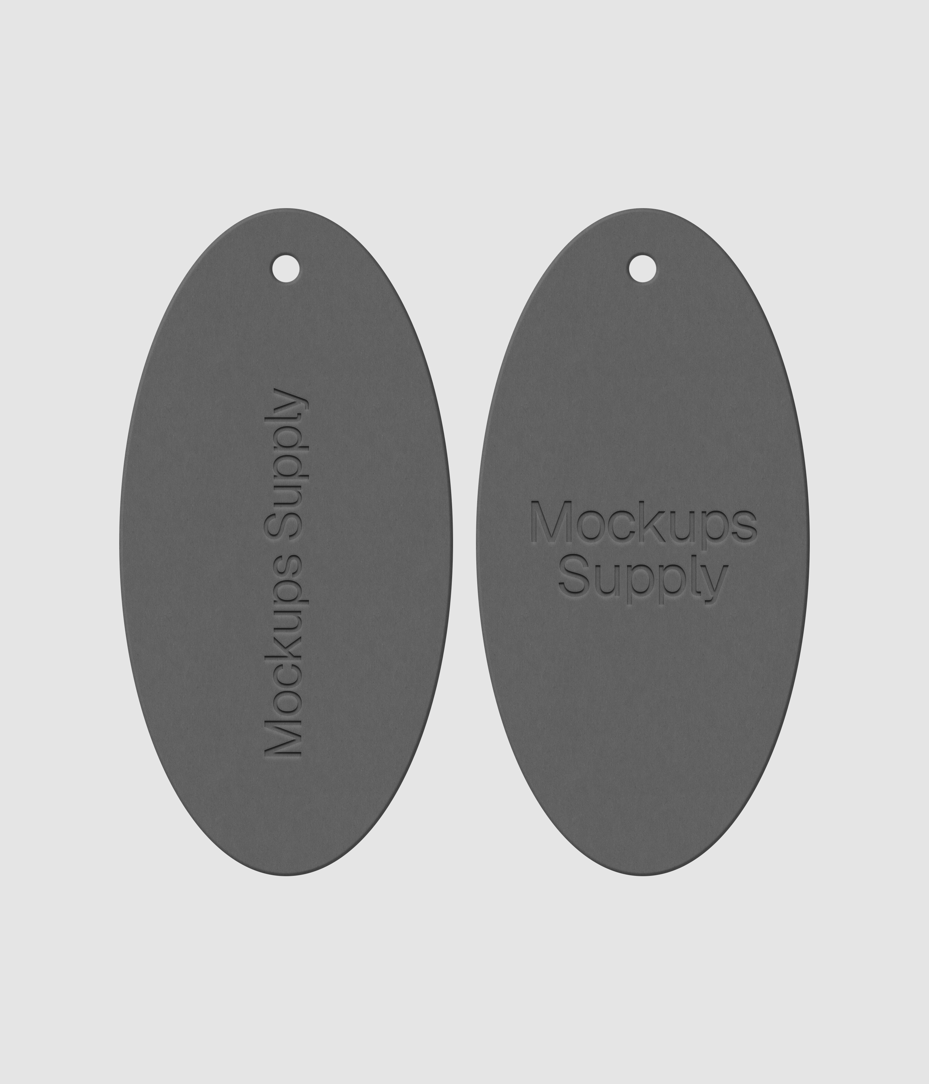 Pair of white elongated oval clothing tags featuring embossed branding on dark surface for premium fashion mockup collection