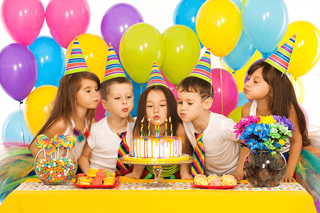 Barn som feirer bursdag med ballonger og kake