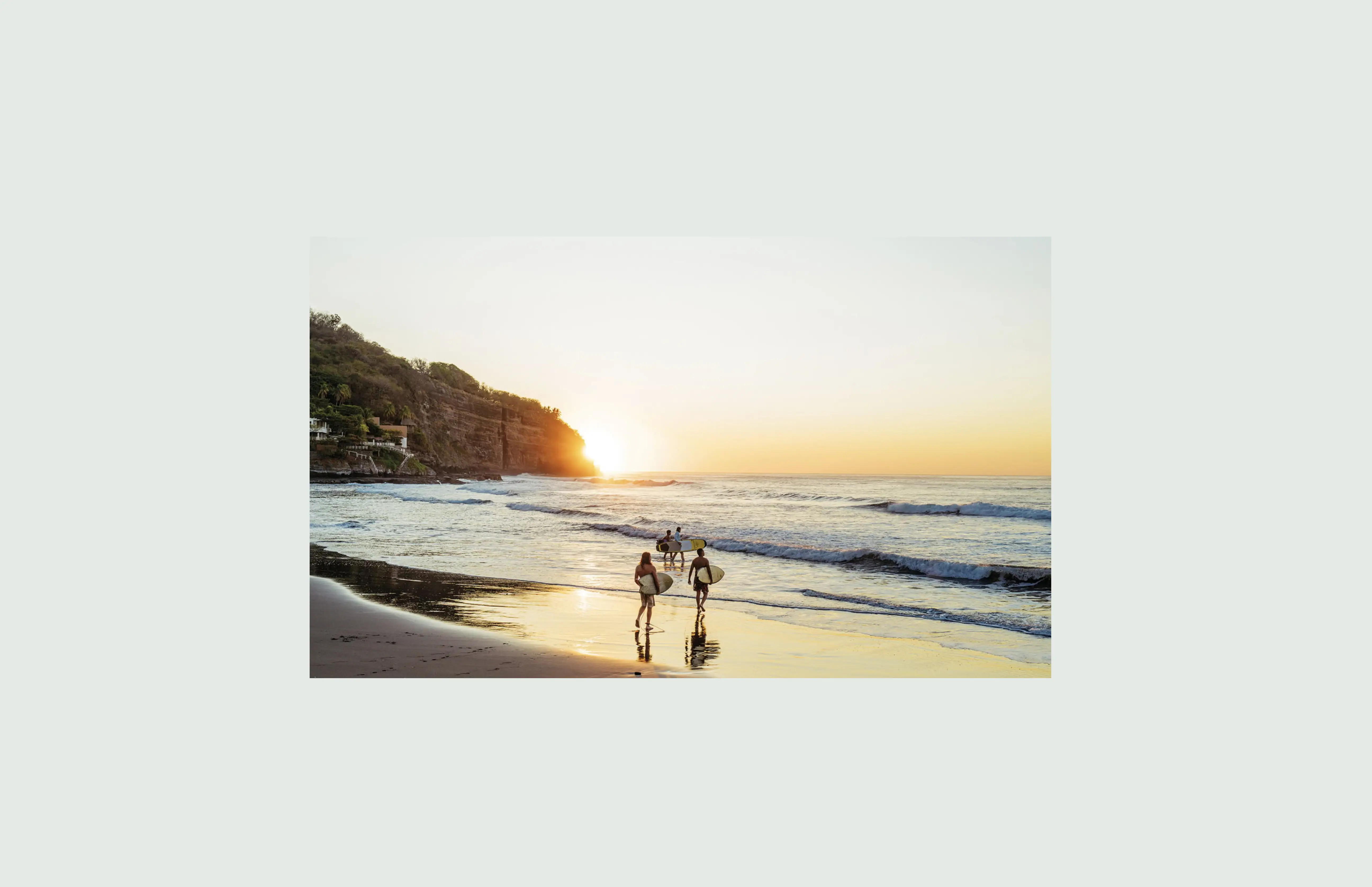 Three surfers walking into the sunset on a beach — where does 0.1 BTC take a surfer and for how long? Eight destinations ranked in satoshis, May 2026.
