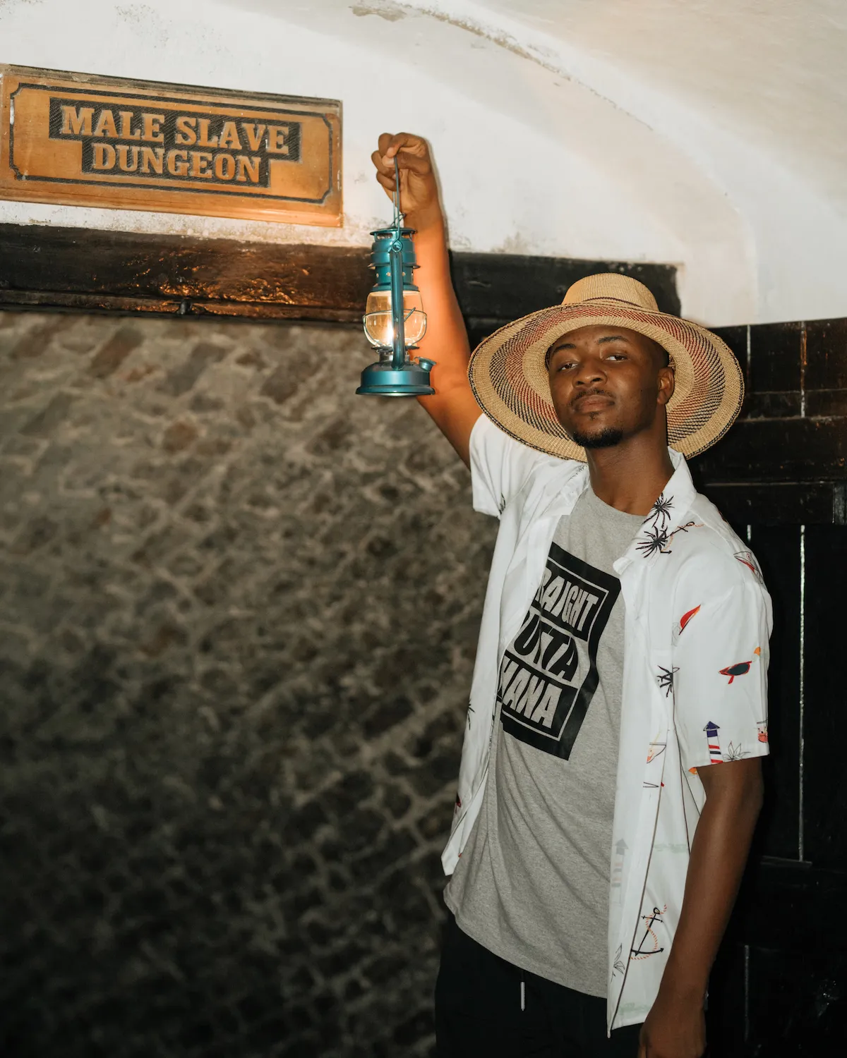 A traveler explores a historic dungeon at Cape Coast Castle.