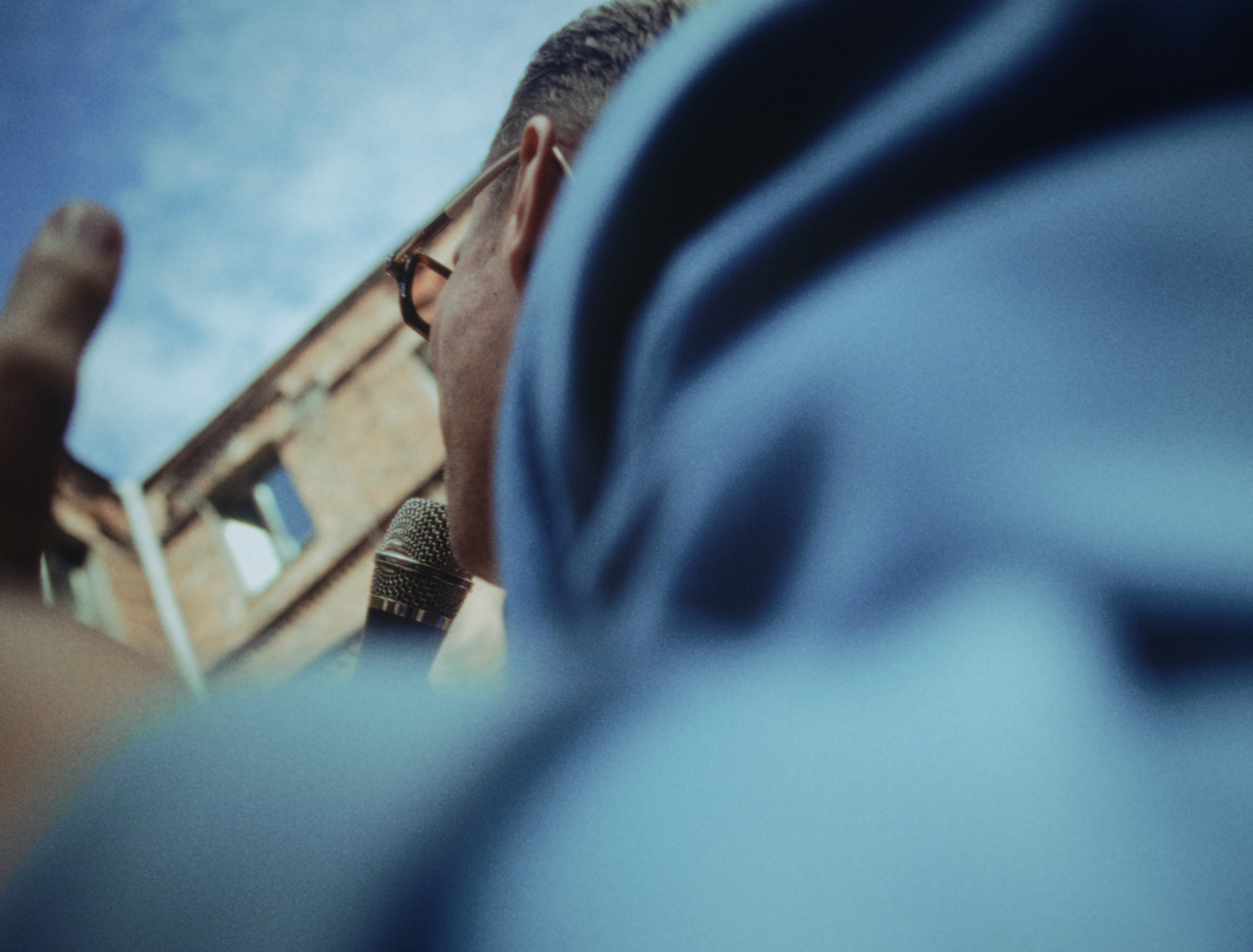 a low-angle view of a singer in a blue jacket