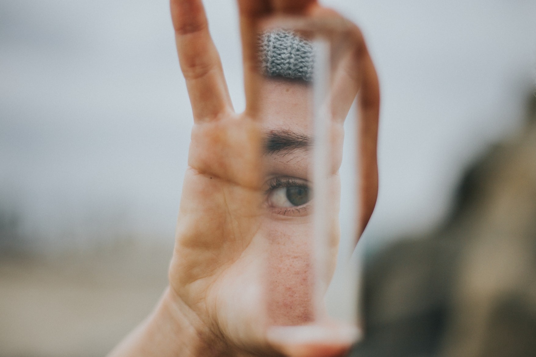 Hand holding mirror with eye.