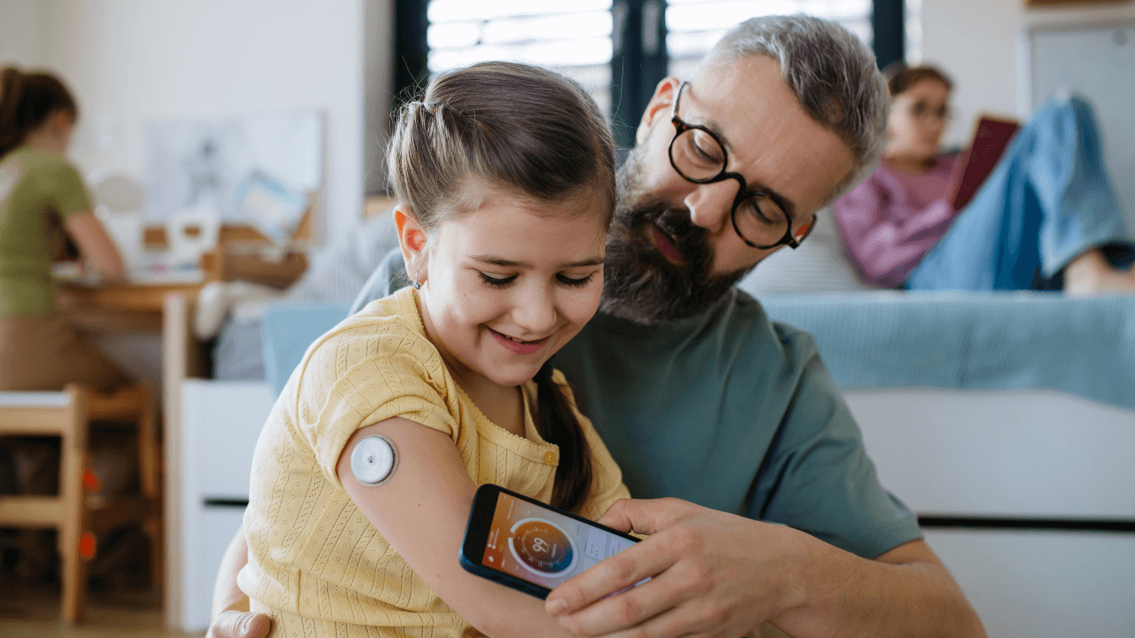 A father helping her daughter manage her diabetes using Dexcom Stelo