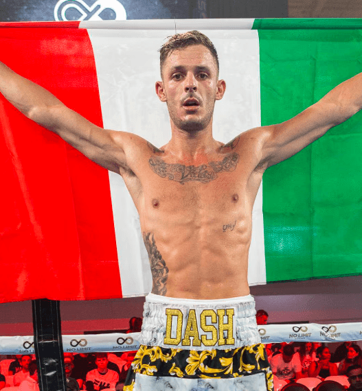 Danilo Dash Creati flexing proudly in front of the Italian flag during weigh-ins.