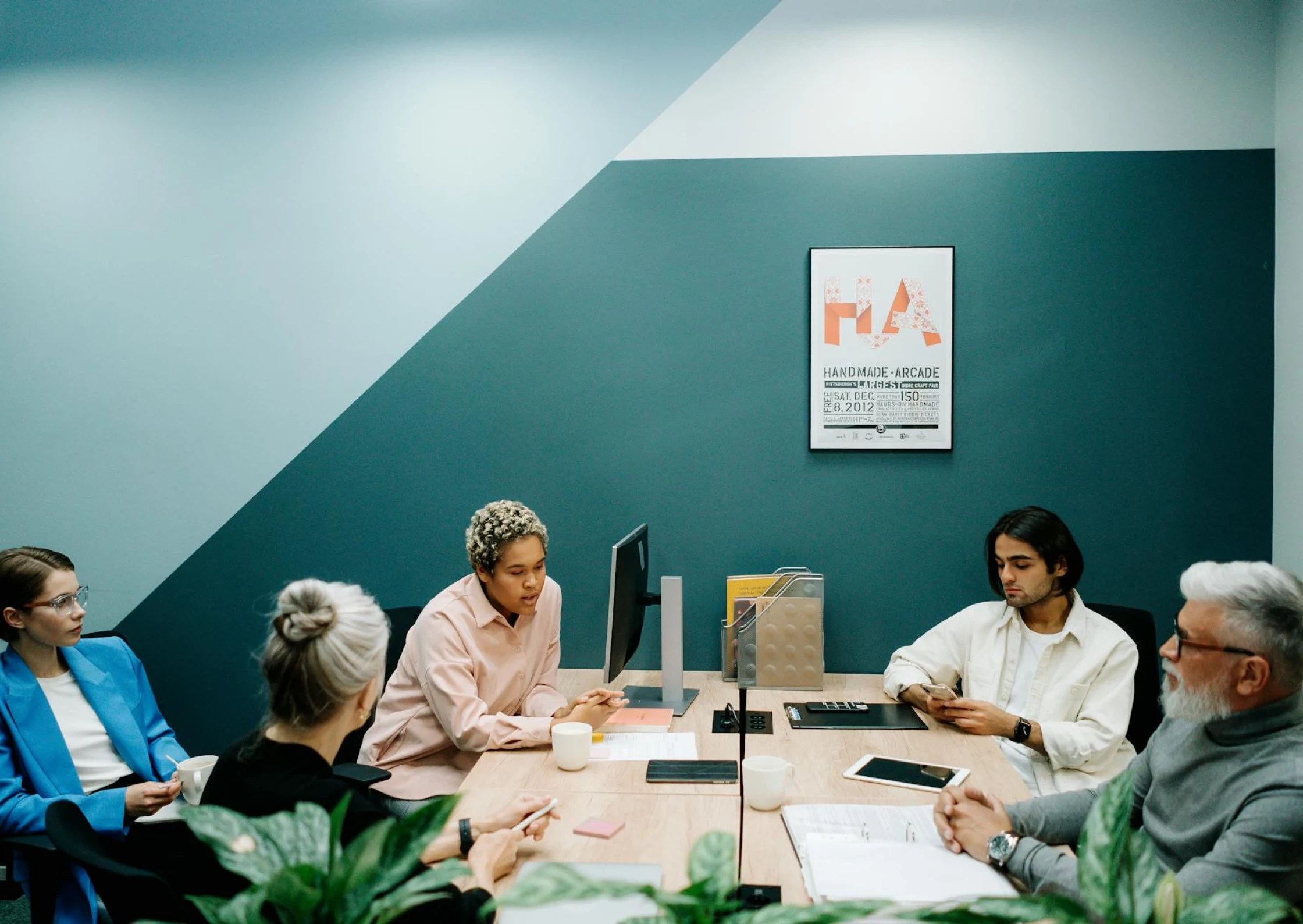 An office room with different people seated around a table.