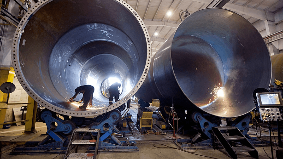 Operários trabalhando em grandes caldeiras de metal, destacando a precisão e o acabamento em serviços de caldeiraria industrial oferecidos pela Agmol.