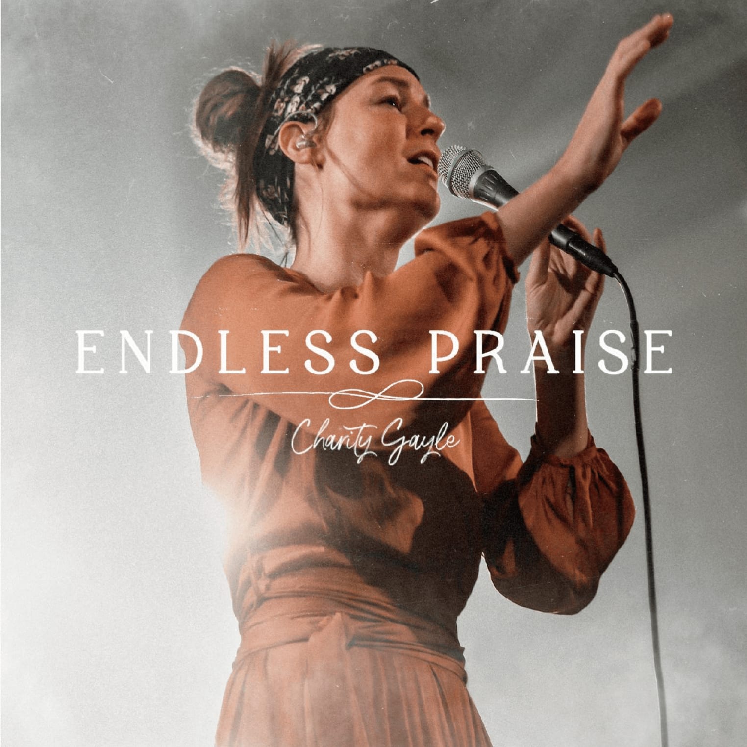 Album artwork for "I Speak Jesus" by Charity Gayle featuring a woman in a rust-colored dress singing, with song title and artist name overlaid.