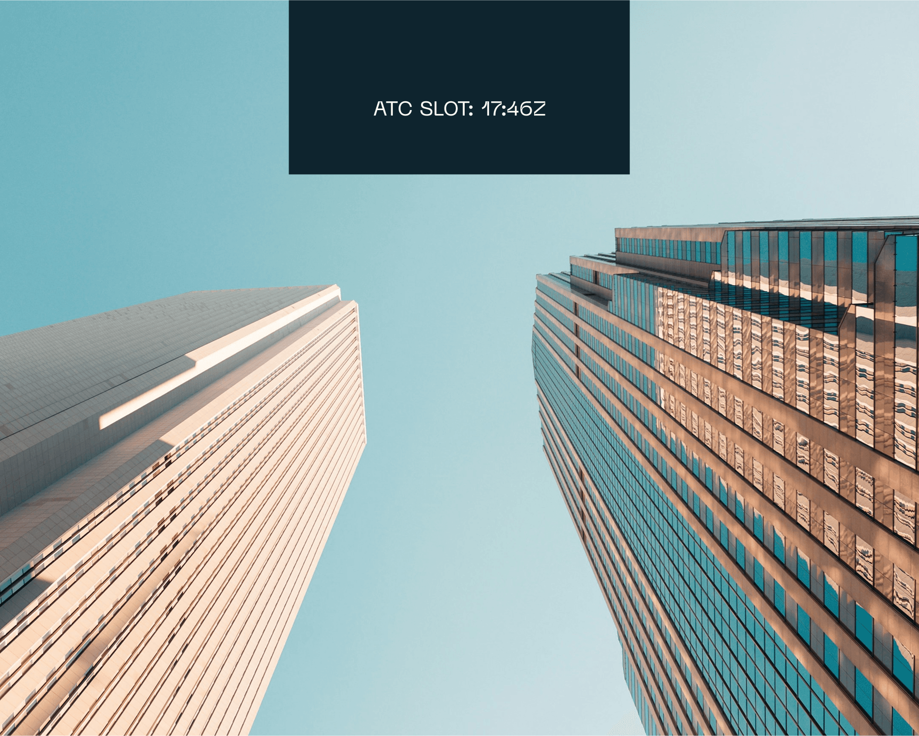 A low-angle view of two modern skyscrapers under a clear blue sky, with a digital sign displaying "ATC SLOT: 17:46Z" in the center, capturing urban architecture and technology.