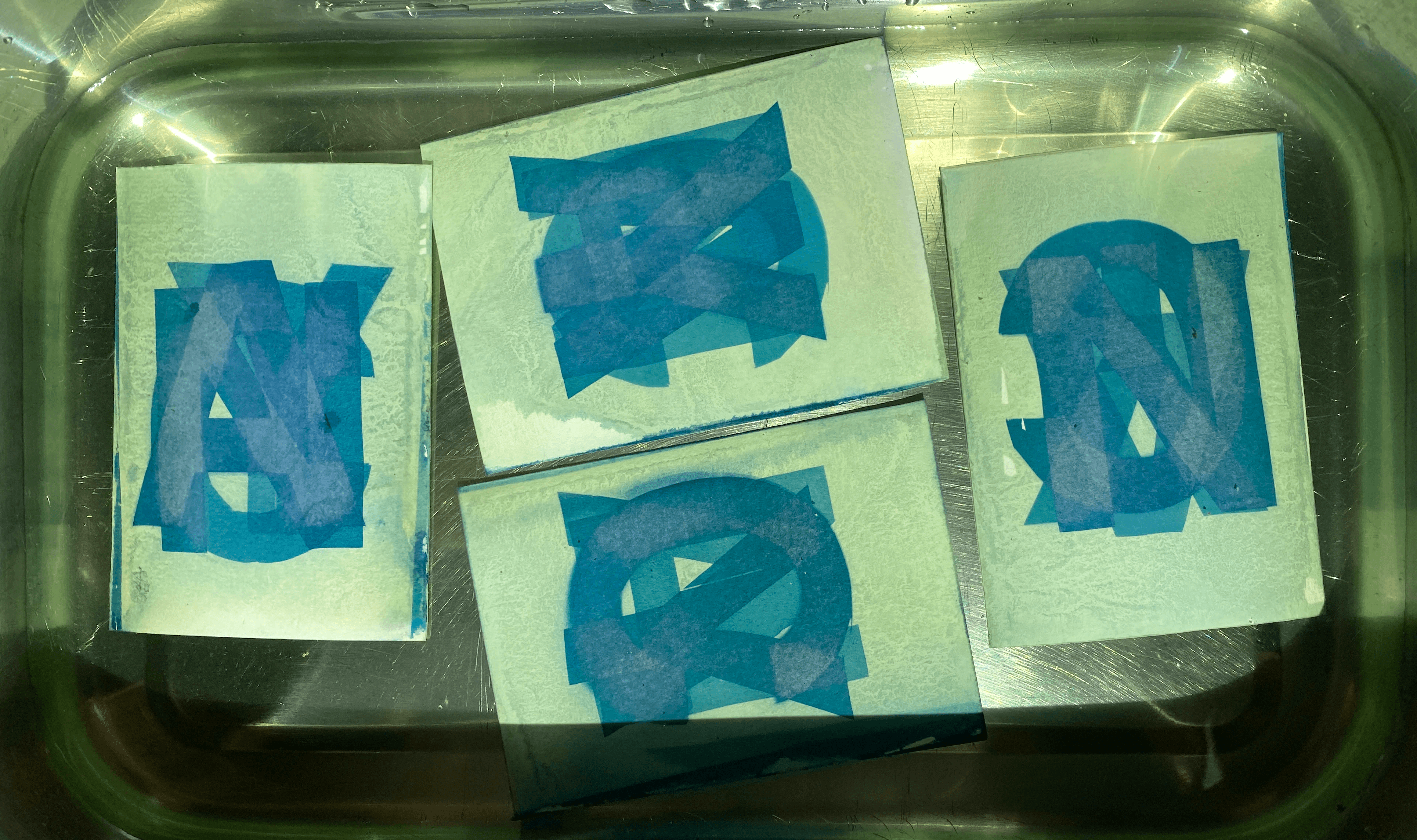 Auftragen der gelb-grünlichen Sensibilisierungs-Lösung auf Aquarellpapier mit einem Pinsel, analoges Design-Verfahren.