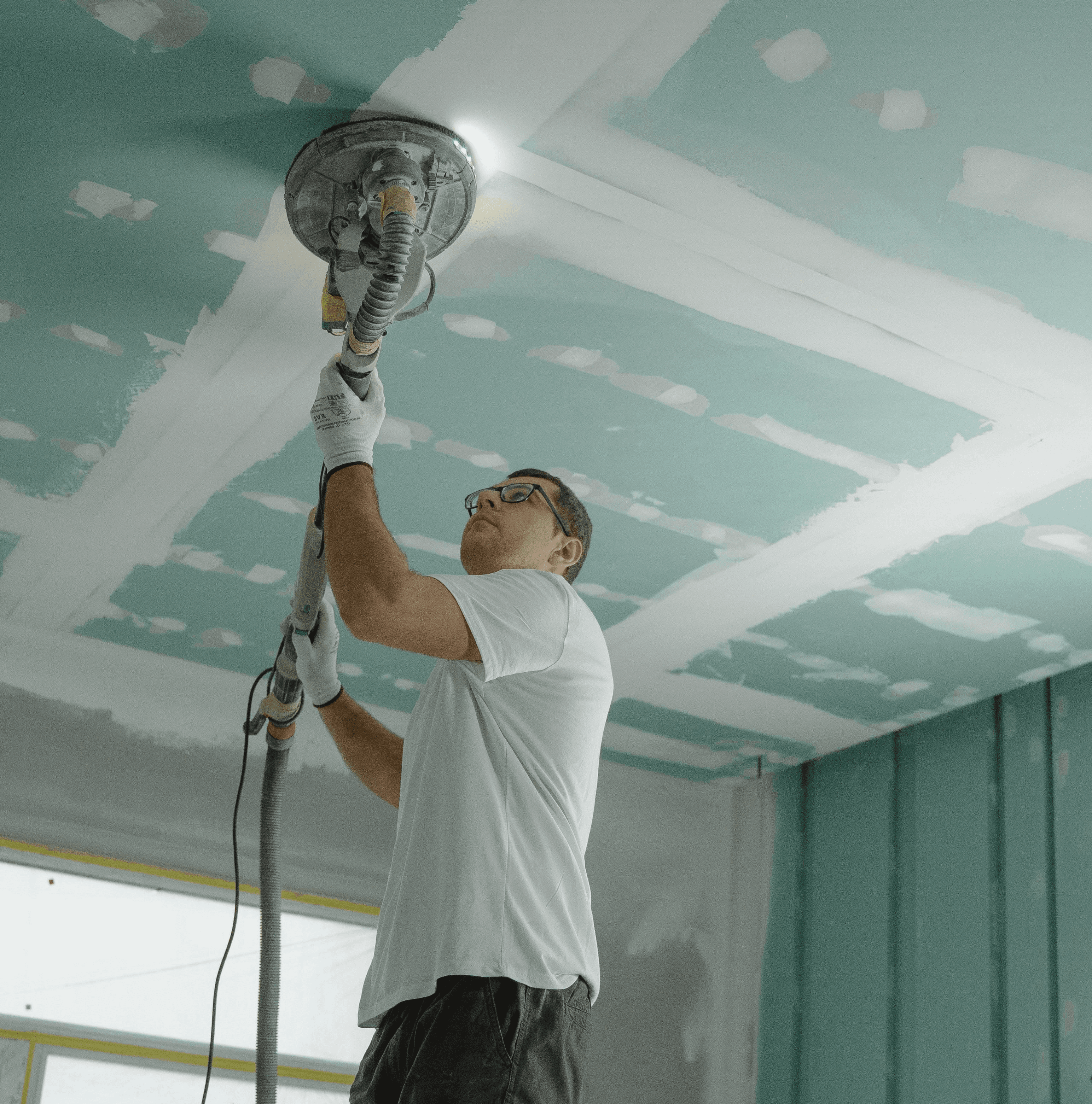 a man painting a wall with a paint roller