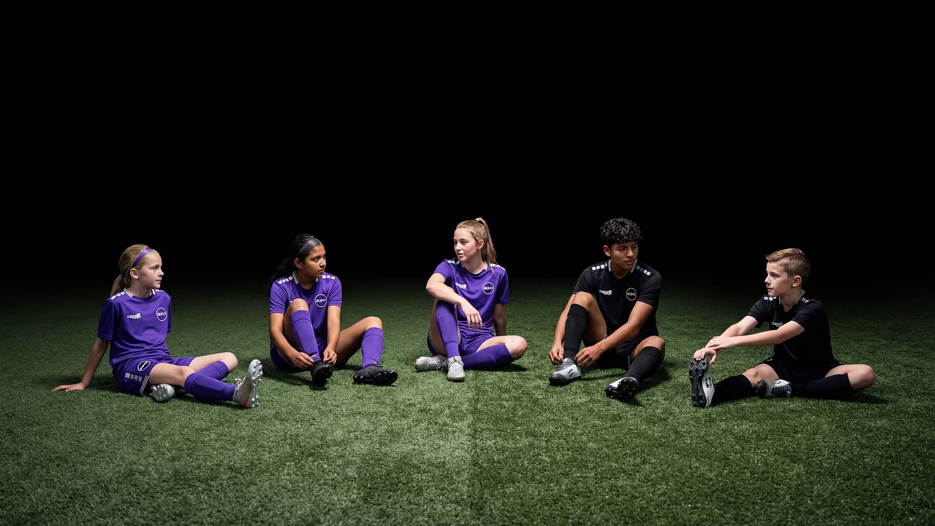 a group of soccer players huddle together on the field