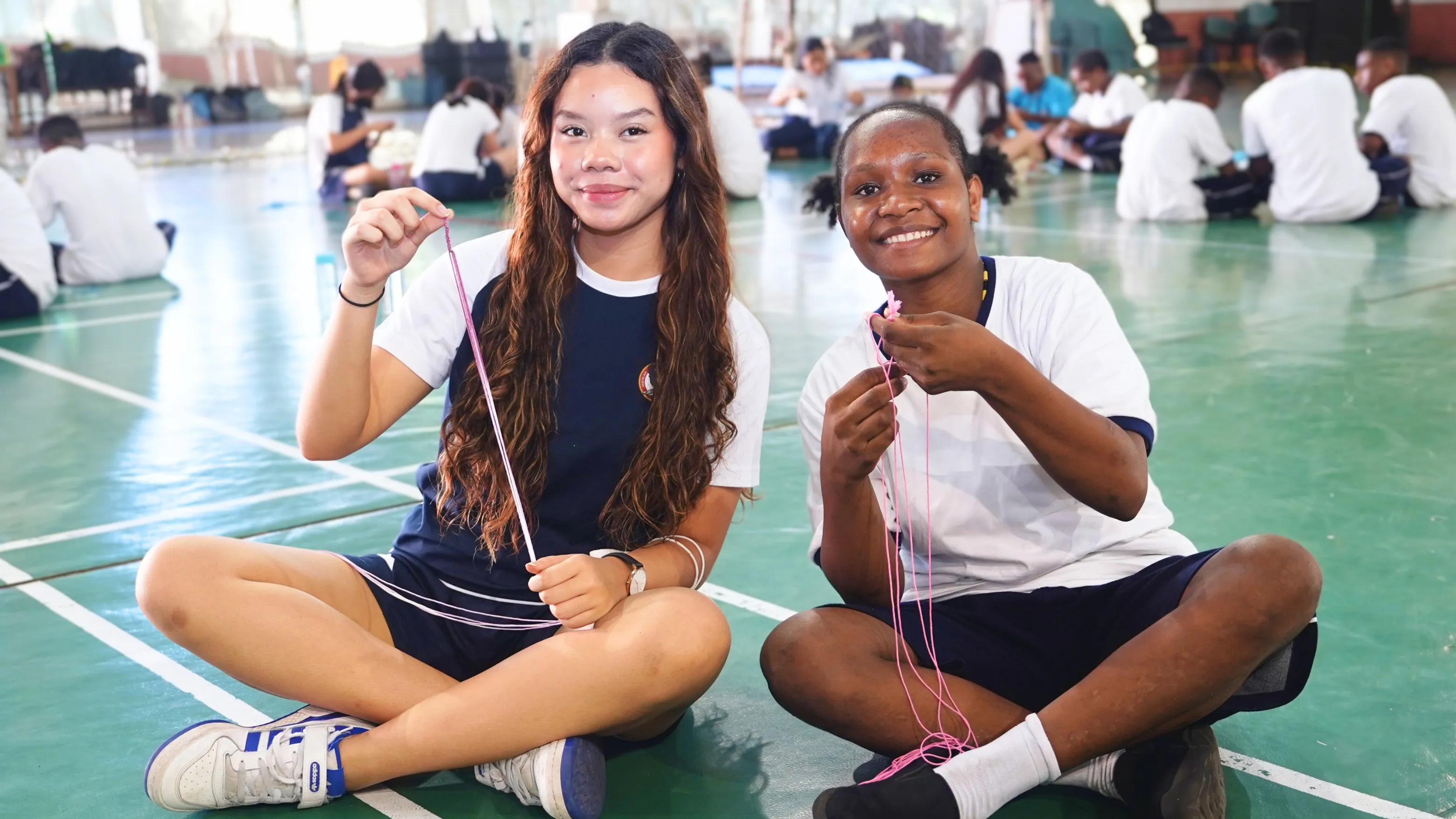 person writing on brown wooden table near white ceramic mug