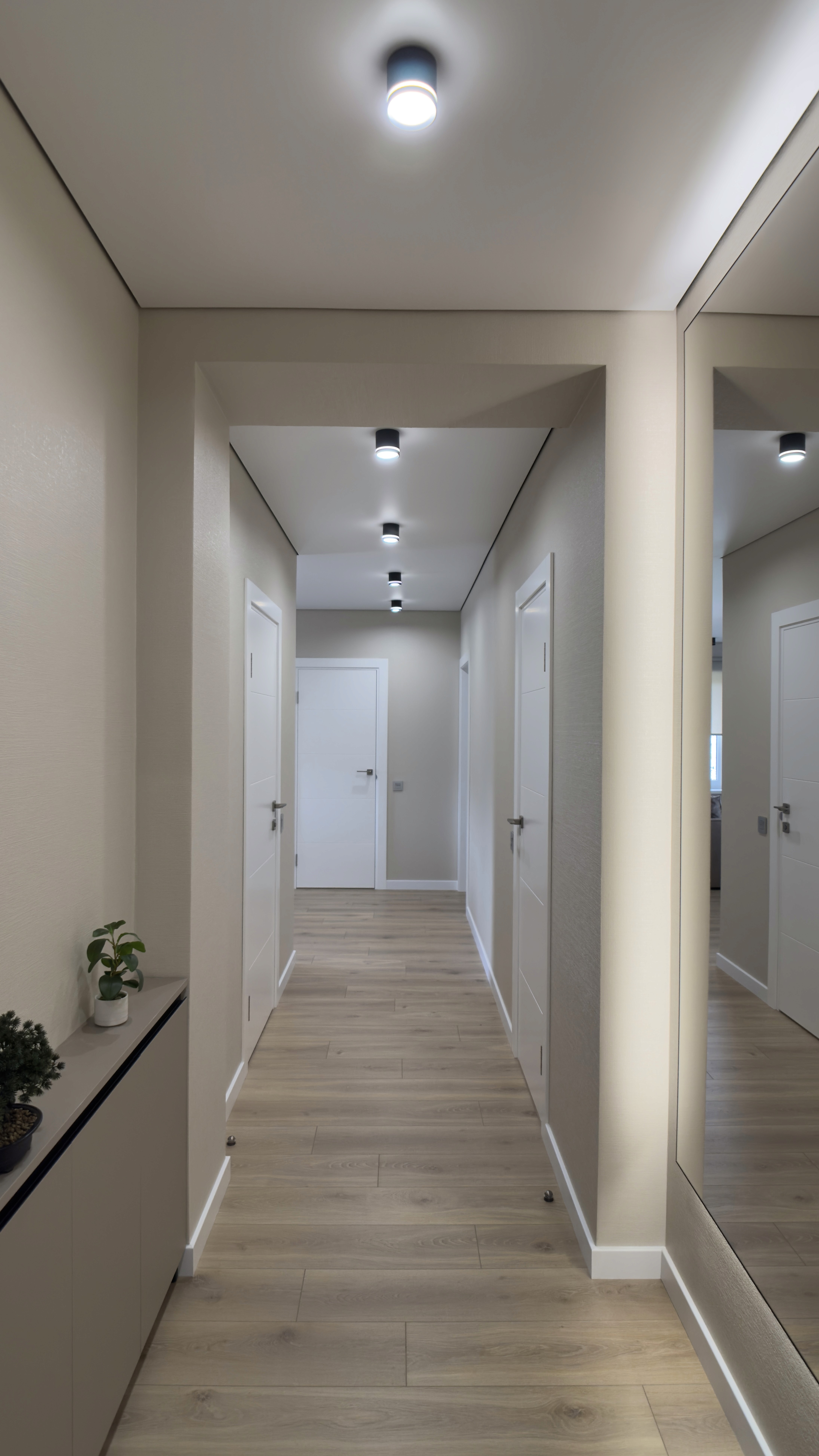 Просторий коридор з дзеркалом на всю стіну та вбудованим освітленням