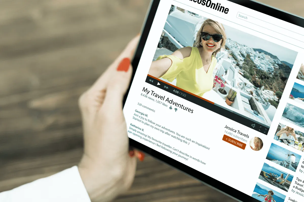 A woman's hand holding an ipad showing a YouTube channel