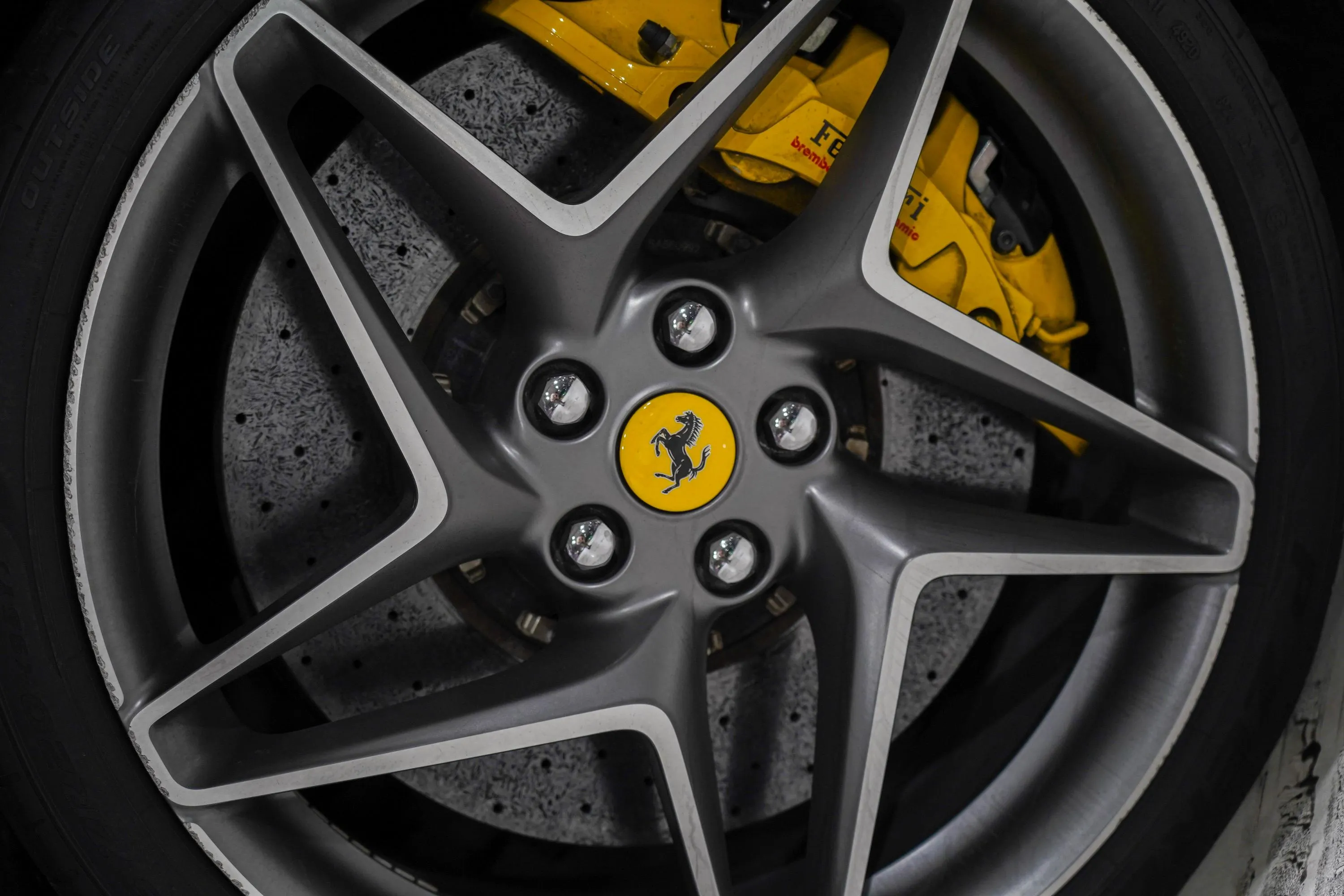 Ferrari F8 Tributo alloy wheel and brake detail, highlighting lightweight rims and high-performance braking system.