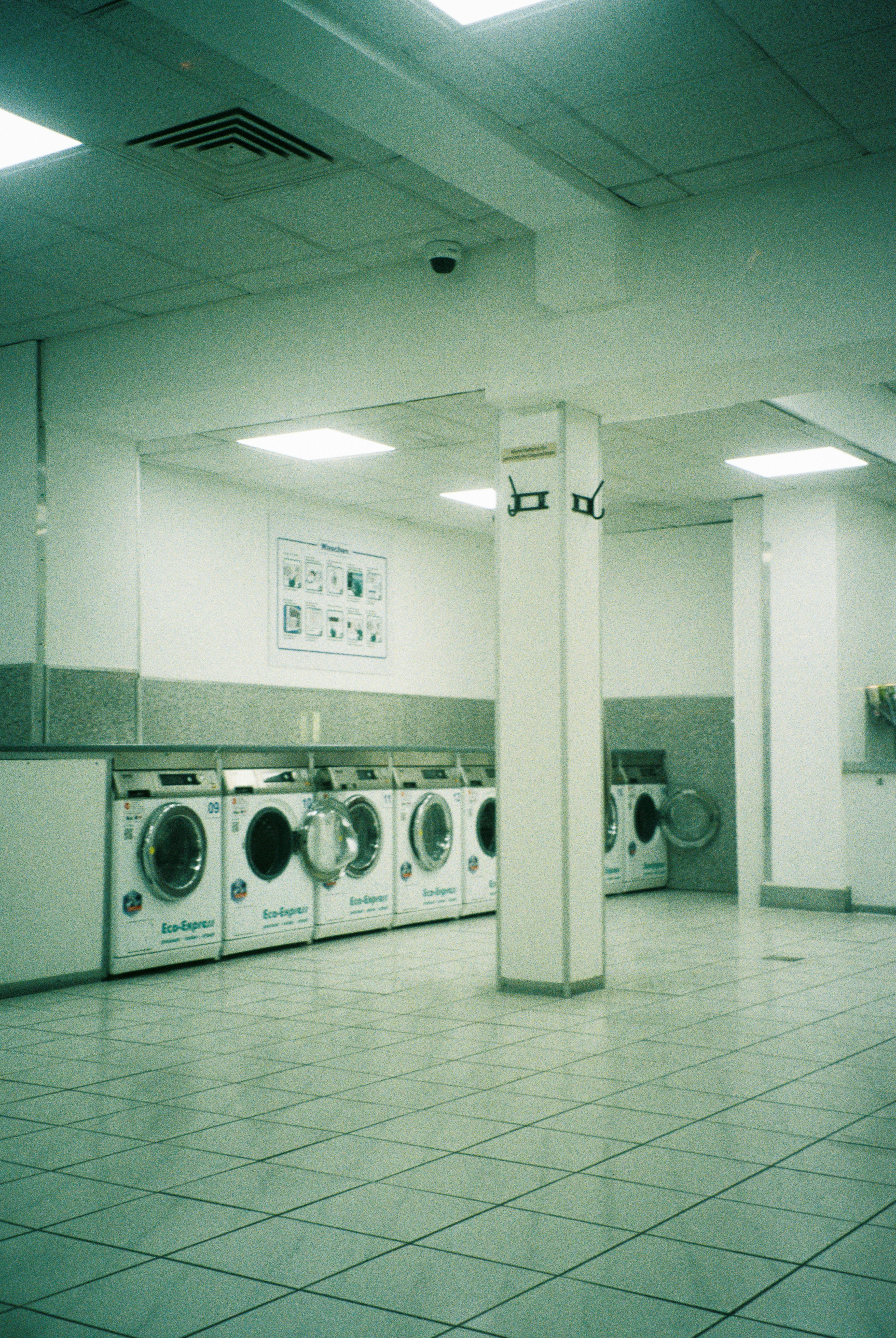 Row of washing machines in a brightly lit laundromat.
