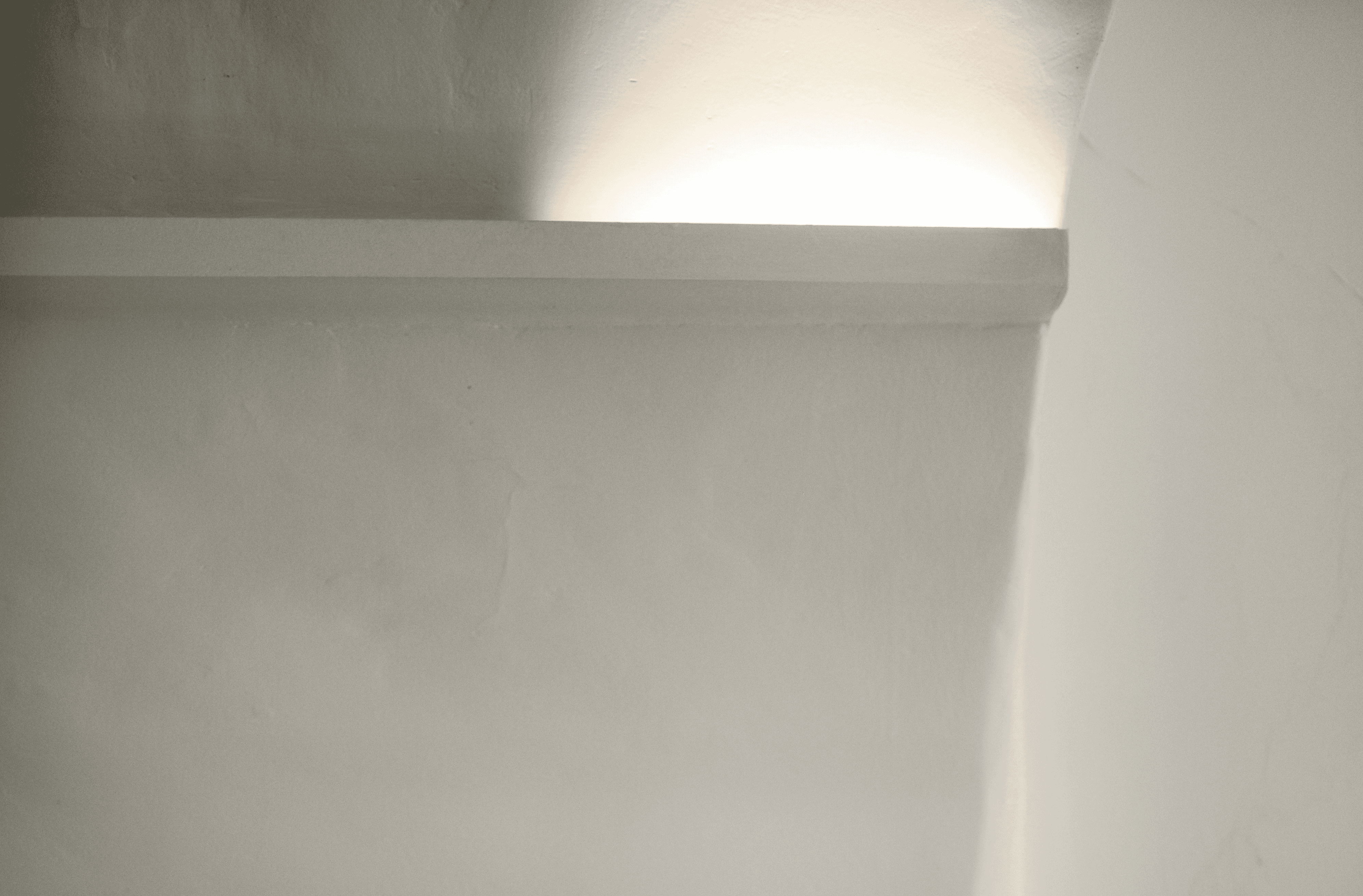 Whit background with light on a ledge