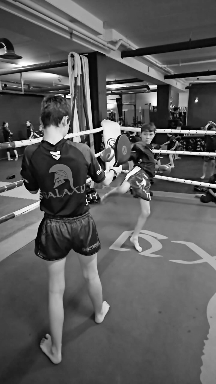 Photo of a young boy kicking a pad