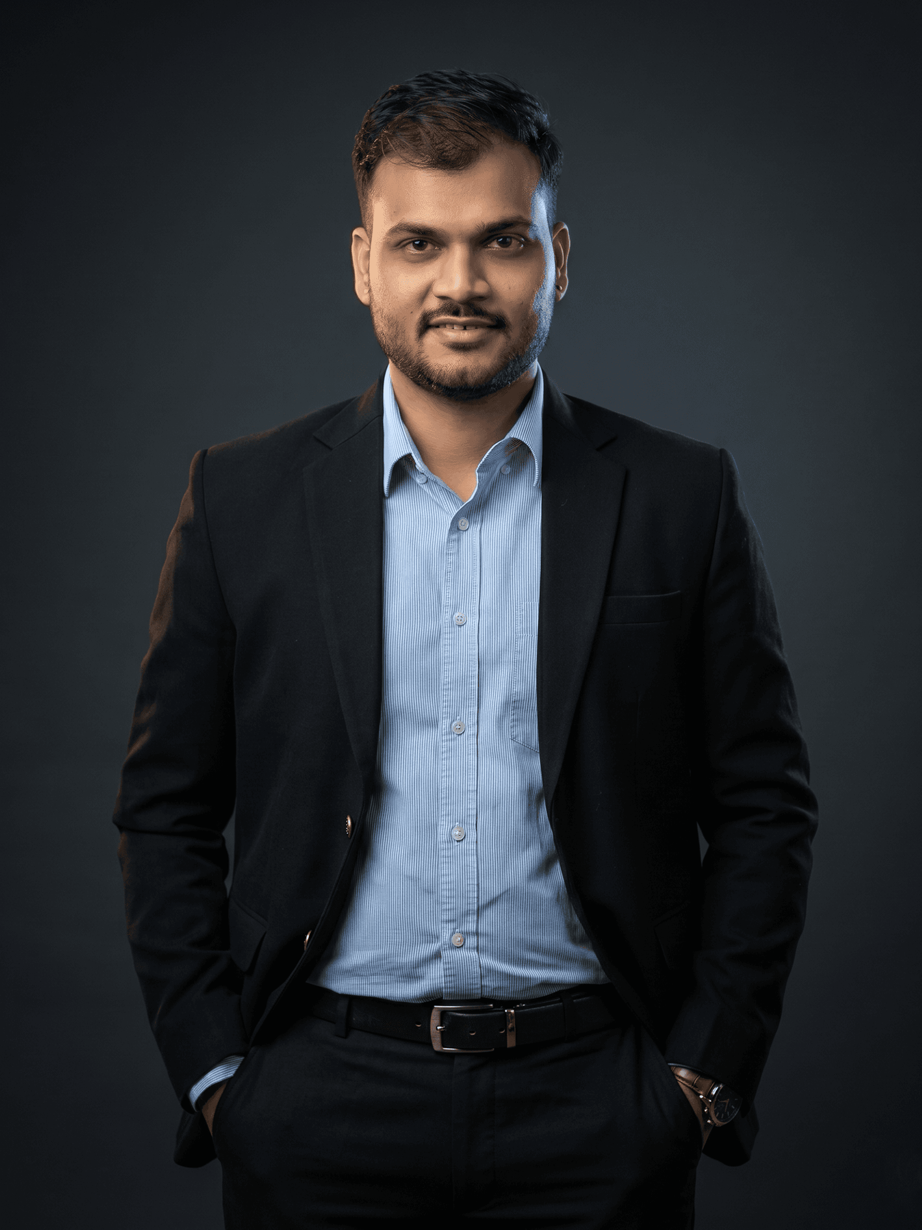Professional portrait of Rankawat Group Jaipur team member in formal black suit and white shirt, confident corporate profile headshot for real estate company website.