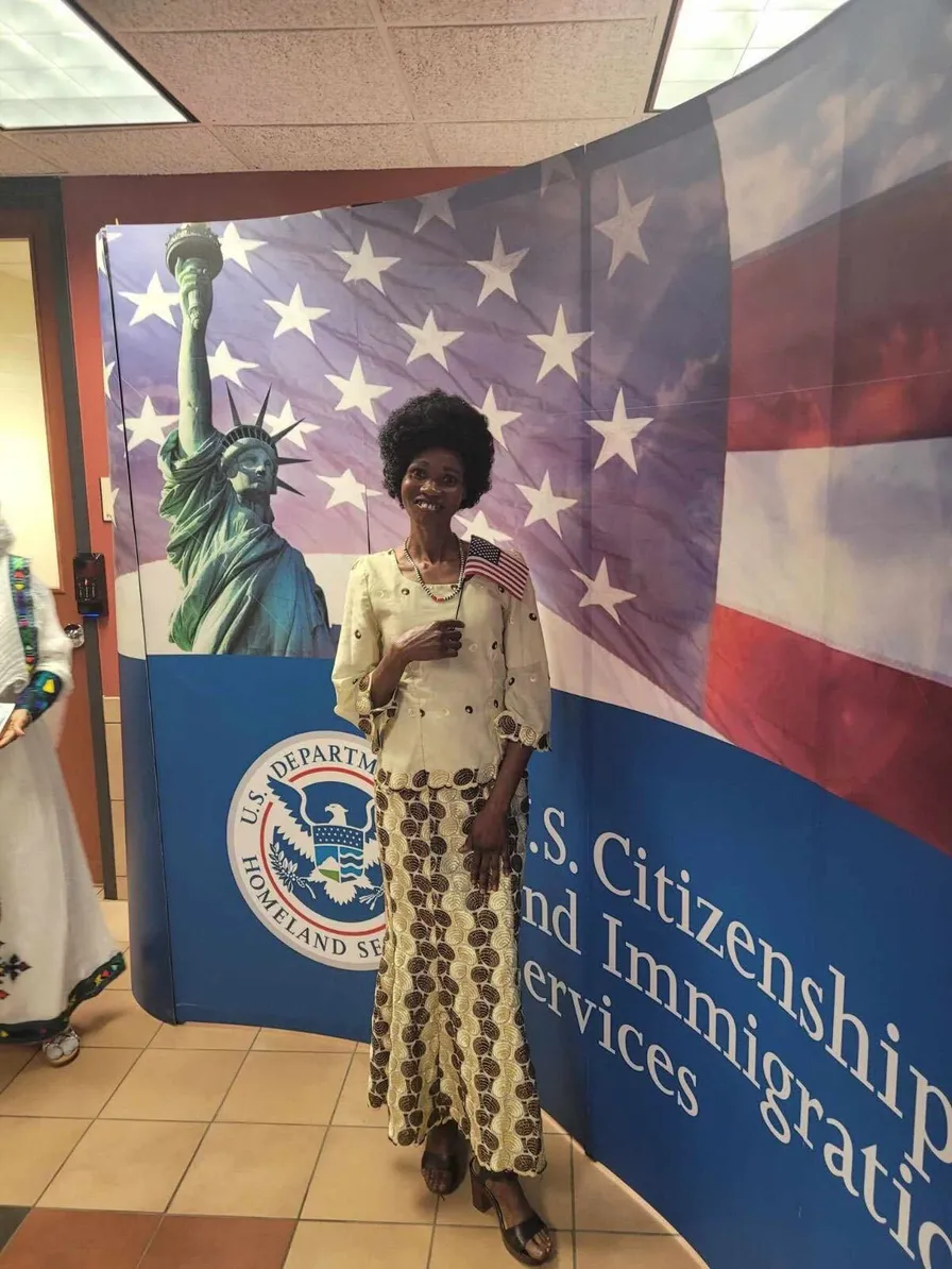 Ecstatic individual holding U.S. flag after naturalization, aided by Fibi Law