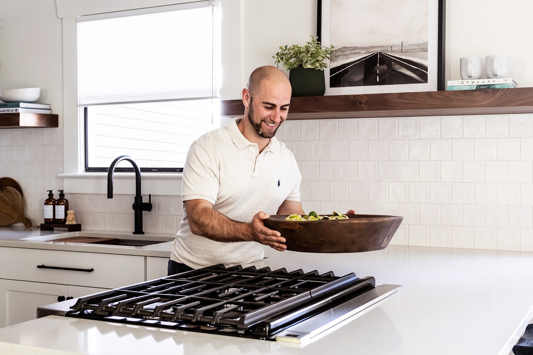 John Monte placing decor in a remodeled Beacon Hill House kitchen. The kitchen of The Beacon Hill House Remodel by interior design + professional organizing firm, Elegant Simplicity.