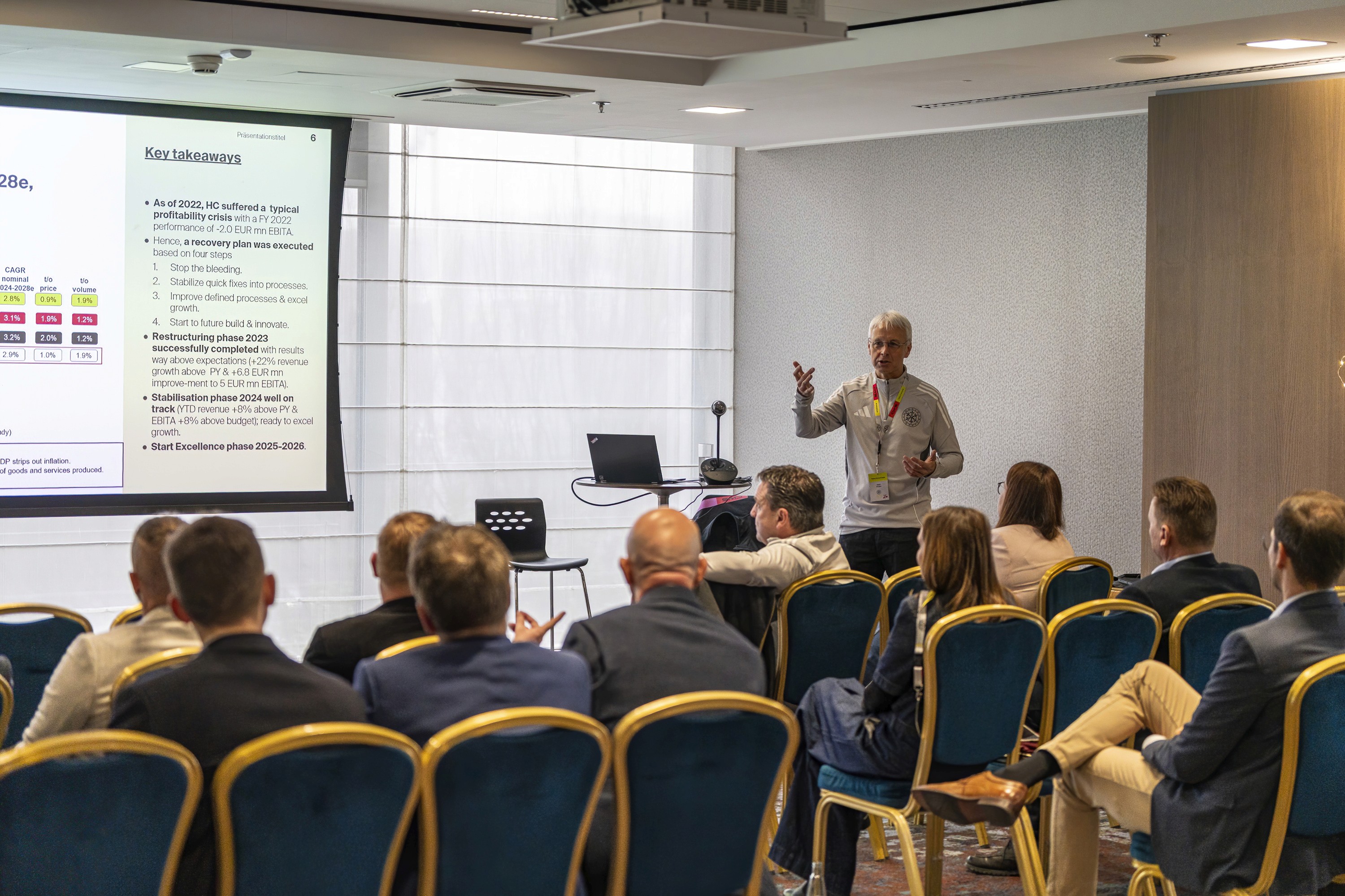Workshop session with a presenter speaking to attendees during a conference.