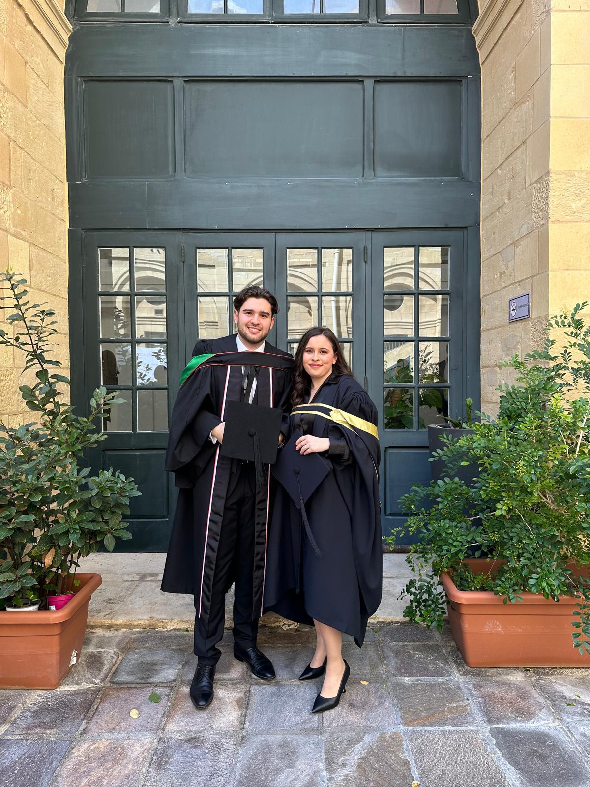 A woman with long blonde hair, in a brown top and jeans, walks through a sunlit forest, holding someone's hand. The scene is warm and inviting.