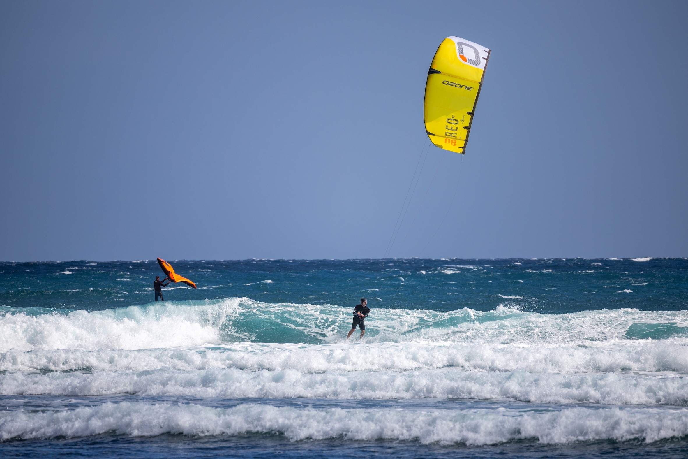 Kitesurfista y wingfoiler en mar picado