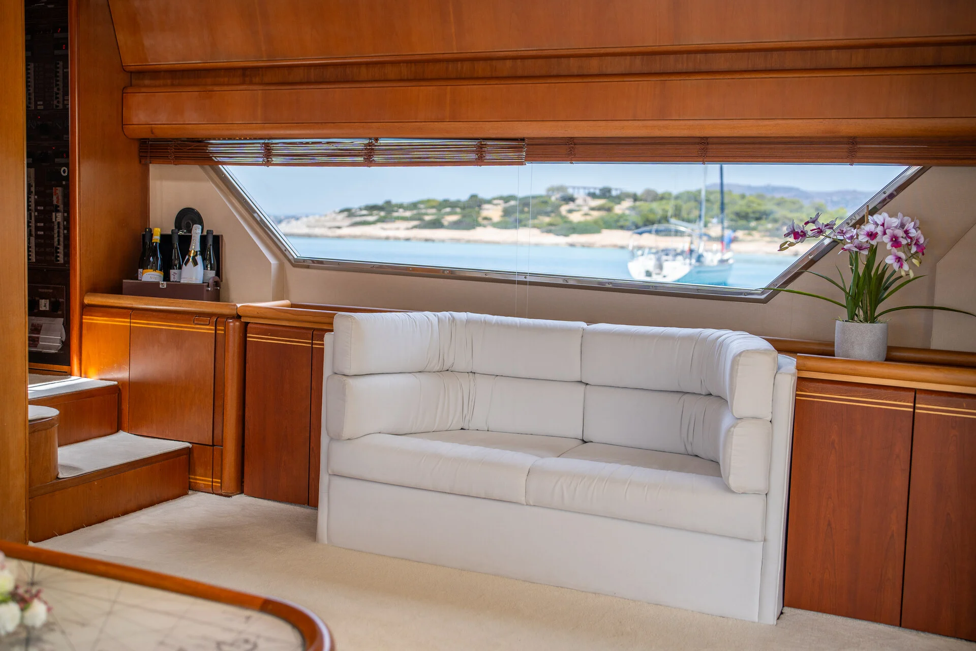White Rock 36 speedboat with captain at helm cruising calm blue waters near Paros coastline with hills in background.