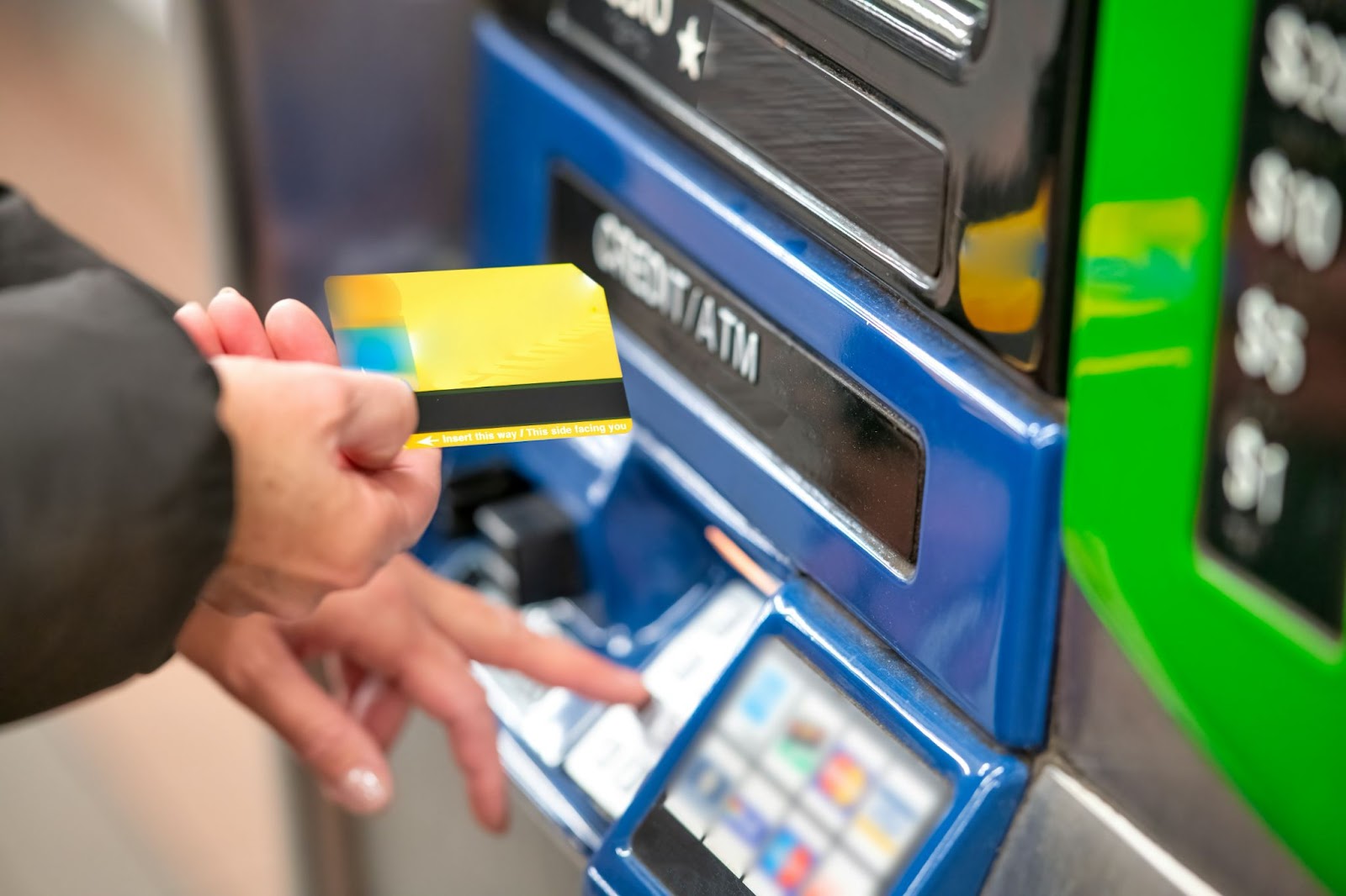 Someone putting their bank card into an ATM