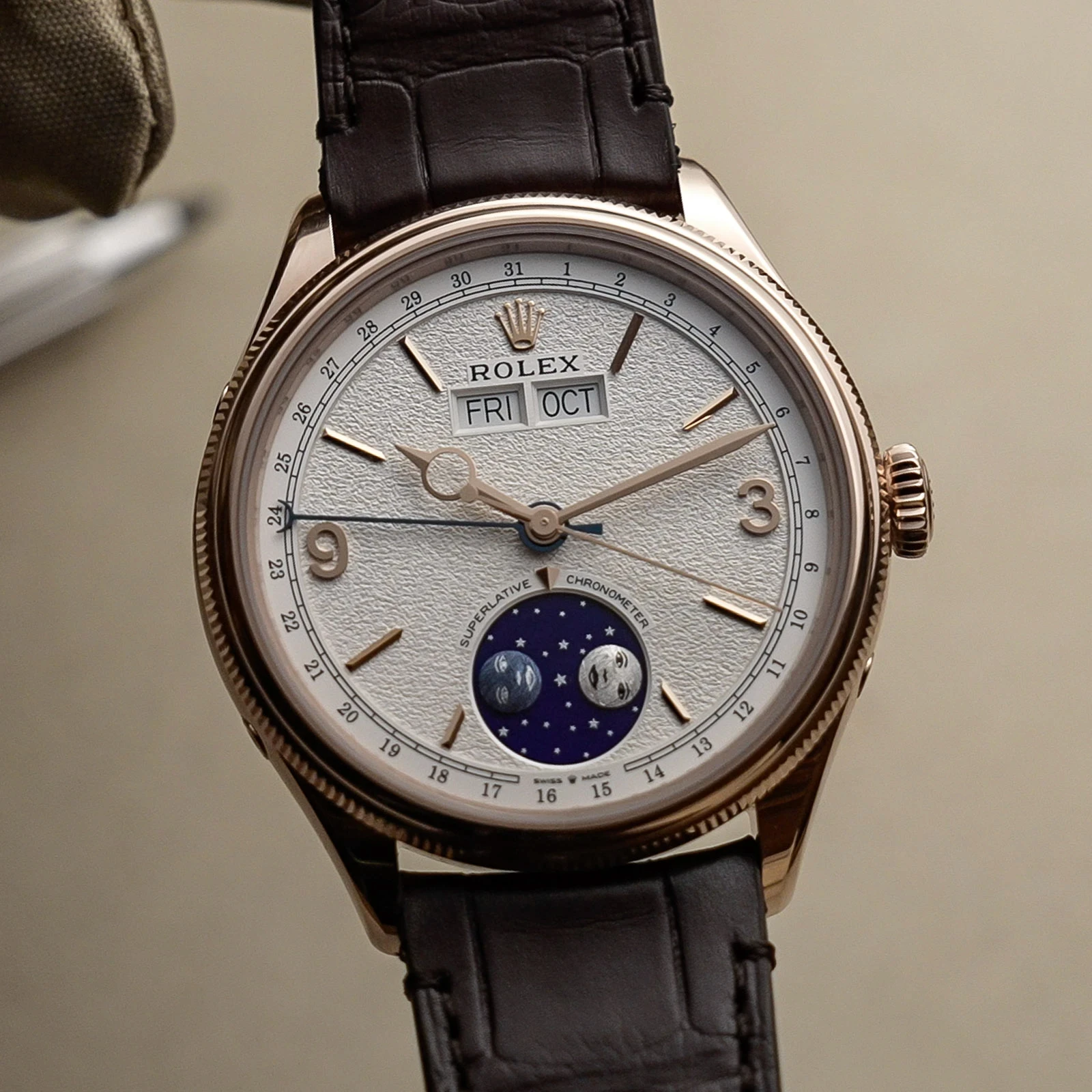 Rolex Perpetual Padellone in Everose gold with a white dial, day and month windows at 12 o’clock and a moon phase at 6 o’clock, on a brown leather strap