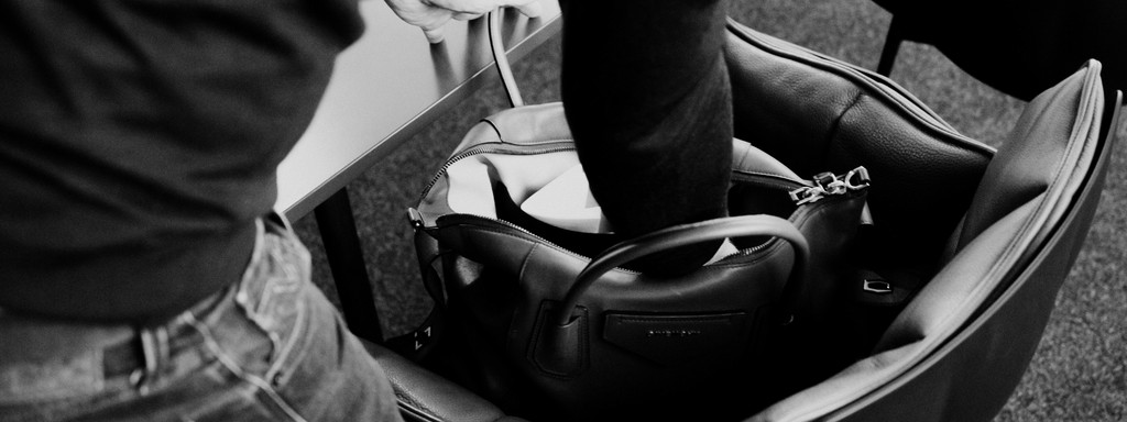 Black-and-white image of a man reaching into a briefcase