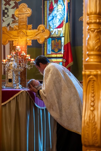 Preot în timpul slujbei de botez, cadru documentar surprins natural.