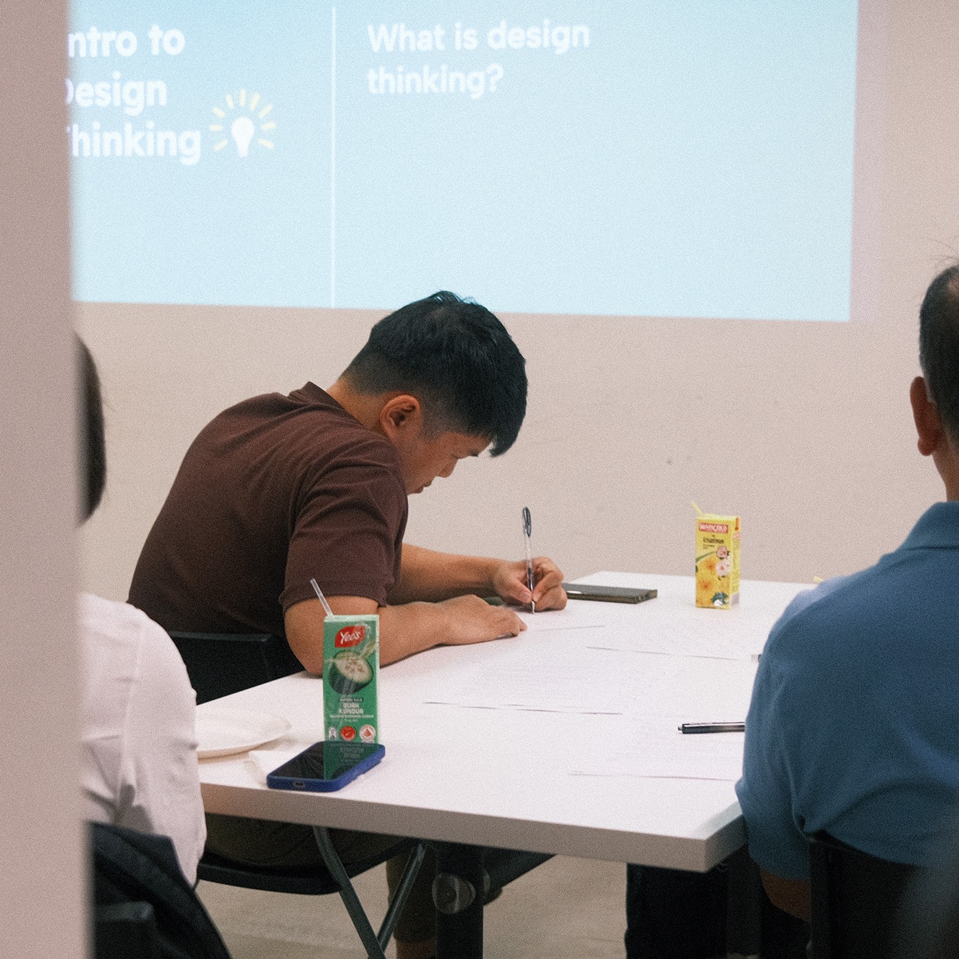A backview shot of a participant writing down notes on a piece of paper.