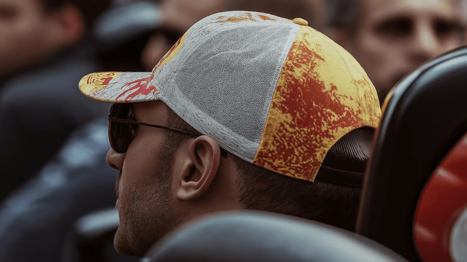 Man with colorful cap and sunglasses sitting in a vehicle