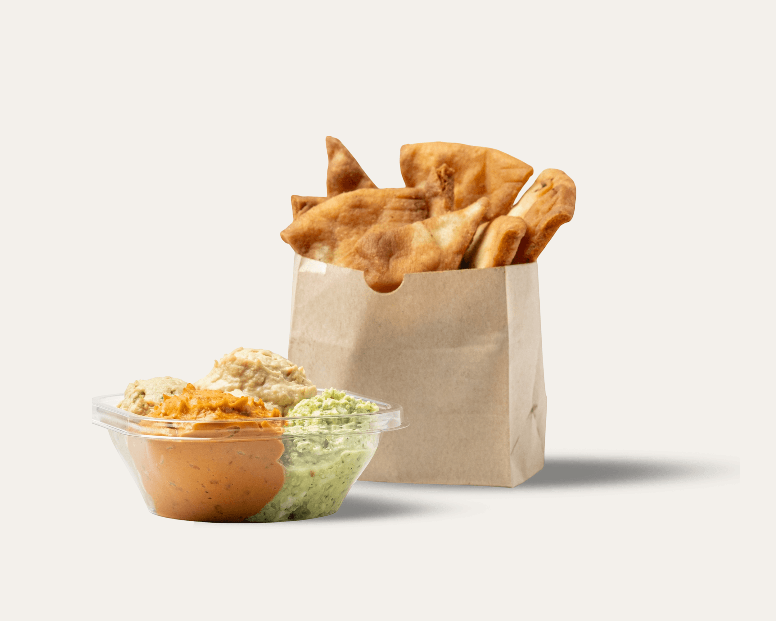 Pita chips in a small paper bag with a small plastic container of various scoops of hummus