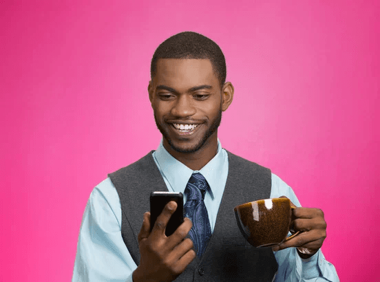 A person holding a chocolate cigarette and smiling.