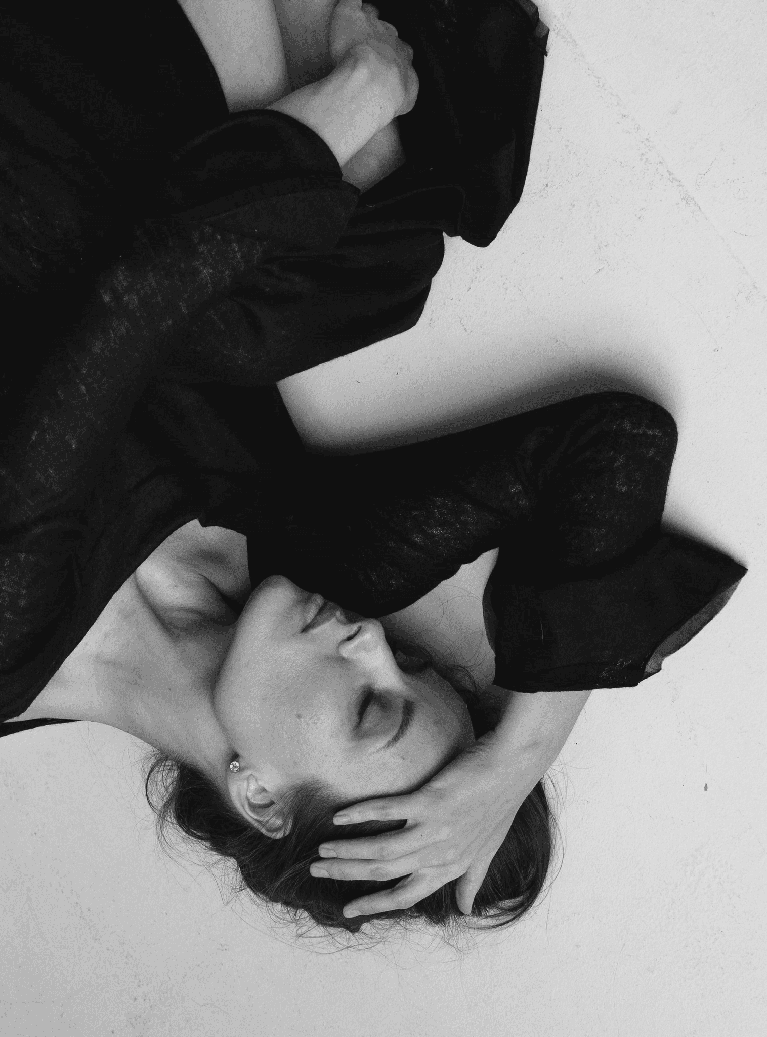 A woman laying on the ground with an aerial view shot