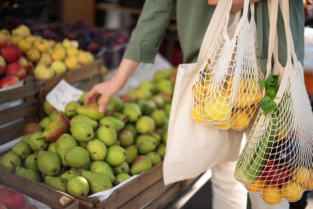 image of grocery shopper using reusable tote bags made from recycled material