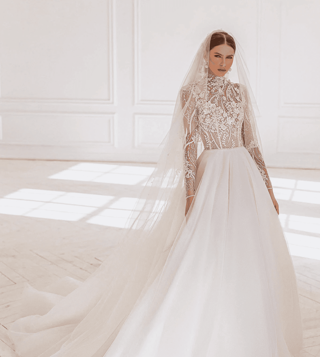 Hochgeschlossenes Brautkleid mit transparenten Spitzenelementen und langen Ärmeln