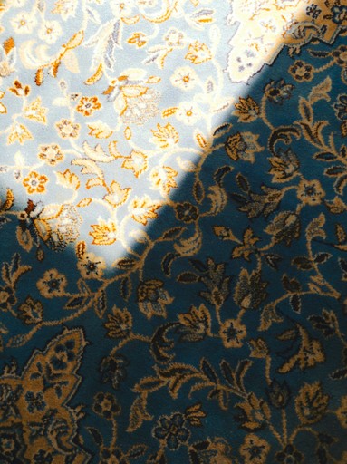 A piece of blue and gold fabric with a flower pattern